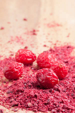 Dried and ground cranberries on a wooden tableの写真素材