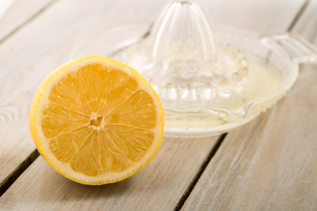 Fresh lemon with lemon squeezer on a wooden table  Close up の写真素材