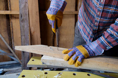 screwing a screw into the a wooden boardの写真素材