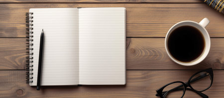 Coffee cup, notebook and eyeglasses on wooden tableの素材