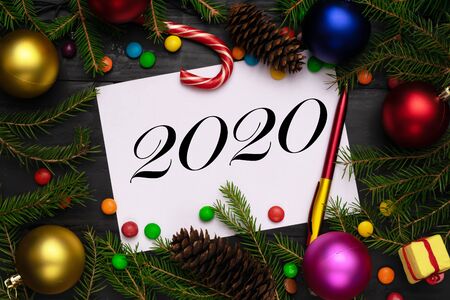 2020 new year background, green fir branches, red and blue , pink, golden balls, candies, cone, gift boxの写真素材