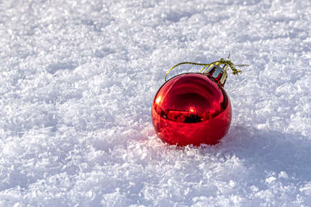 one red christmas ball on white snowの写真素材