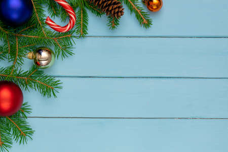 Christmas back, ground, green fir branches, red and blue ball, candies, cone, blue boardsの写真素材