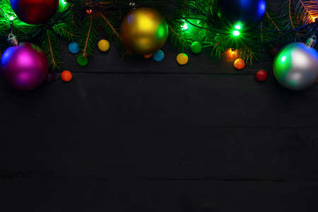 Christmas back, ground, green fir branches, red and blue, pink, yellow balls, candies, garland, black boardsの写真素材