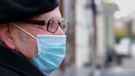 Old grandfather in a protective mask against coronavirus.