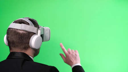 Business worker uses virtual reality glasses on the background of a chromakeyの写真素材