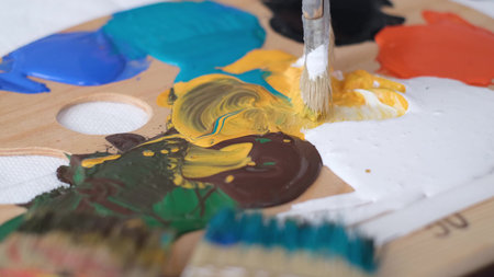The artist dips a brush in the paint, shooting close-up. Contemporary artist creates abstract