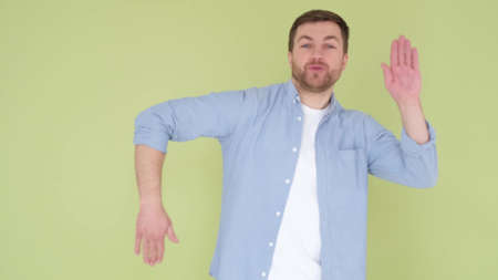 American student dancing on the background in the studio. Man celebrating good newsの写真素材