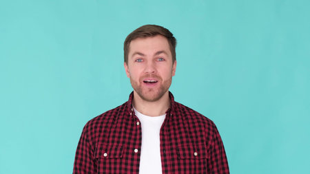 Young cheerful guy of European appearance isolated on blue studio background, say wow, surprised man