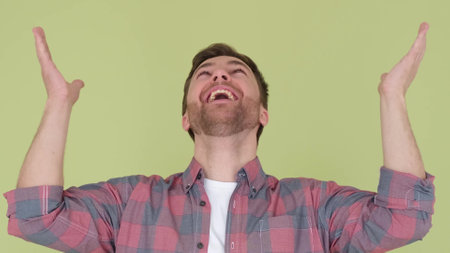 The shocked young man shouts wow, raising his hands. Man rejoices and celebrates successの写真素材