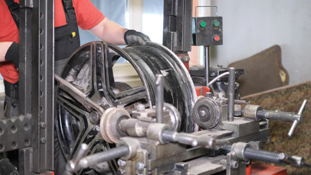 Auto mechanic aligns car rims. Tire fitting Tire machine for rolling and leveling of stynium discs.
