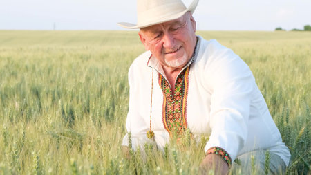 A Ukrainian peasant in an embroidered jacket touches wheat.の写真素材