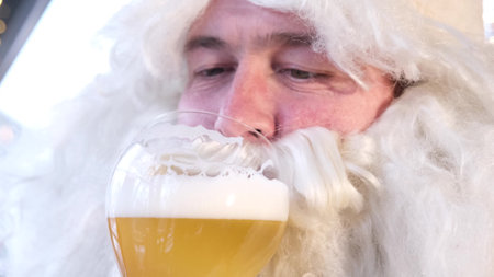 Santa Claus drinking delicious beer, portrait of Santa Claus close up. Merry Christmasの写真素材