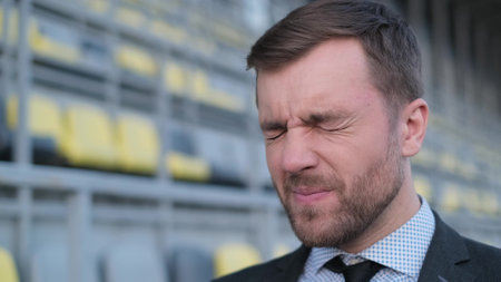 Portrait of a young man in a business suit suffering from a headache.の写真素材