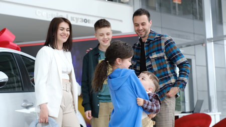Happy family with three children in a car dealership.の写真素材