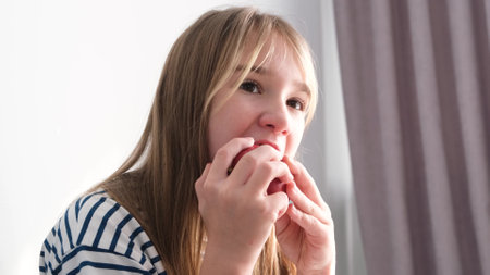 Child girl blonde eats an apple on a white background. Video Delicious ripe autumn fruitsの写真素材