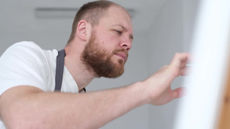 A man is a professional artist who paints a picture in his studio. The concept of creating artの写真素材