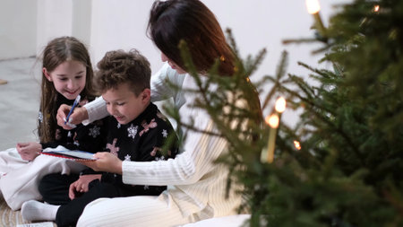 Small children with their family near the Christmas tree. Family values. Concept of Christmas holidaysの写真素材