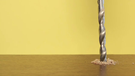 The slow movement of the drill is screwed into the wooden bar. The self-tapping screw is screwed into the woodの写真素材