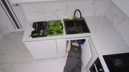 Male plumber cleaning pipes. Clean the drain and sink