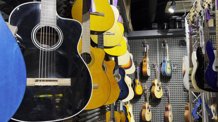 Close up of multicolored acoustic guitars in a store. Stringed musical instruments