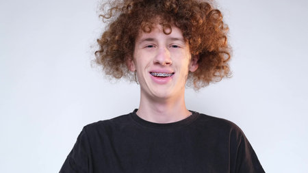 Smiling guy looking at camera on white background in studio
