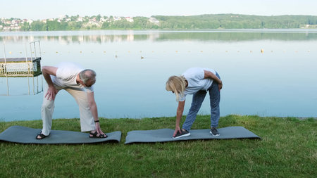 Happy active fit senior couple exercising outdoor.