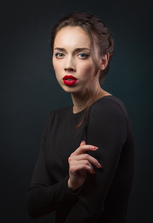 Portrait brunette girl in black dress. Red lips. Fashion. Dramatic lookの写真素材