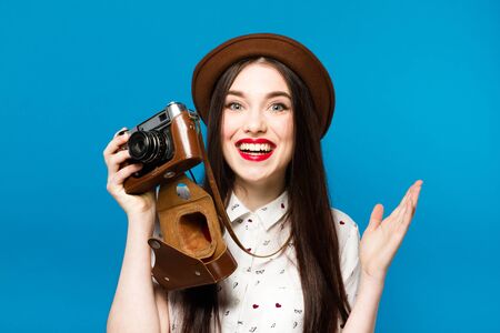 Stylish girl with camera. Blue background. Summer timeの写真素材