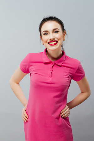 Portrait of a carefree young woman smiling with arms raised.の写真素材