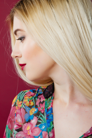 Closeup Portrait of Sensual Blonde with Professional Makeup and Colorful Shirt in Studio on Pink Background.の写真素材