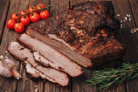 A piece of juicy smoked meat with spices on a wood backgroundの写真素材