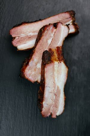 Closeup of pork ribs grilled with BBQ Tasty snack to beer on a paper for filing on dark concrete background. Top view. Flat layの写真素材