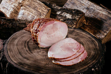 Smoked pork bacon half a piece on a wooden board, sliced ââpork. Top view. Close up.の写真素材