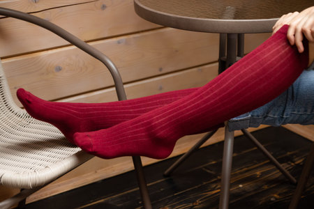 A young Model girl on a chair in violet colored socks sits on a chair and poses. Close-up. High...