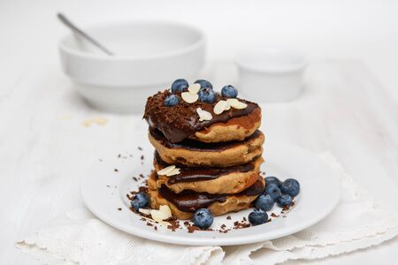 Eggless pancakes for breakfast with blueberries and chocolate sauceの写真素材