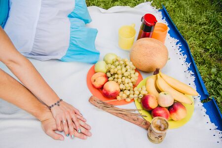Picnic time. Young couple eating grapes and enjoying in picnic. Love and tenderness, dating, romance, lifestyle conceptの写真素材