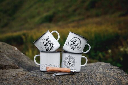 Metal cups with a tourist knife on the rock in the natureの写真素材