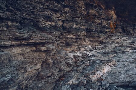 Surface of an stone wall. Black Stone background. Rock texture. Rock pile backgroundの写真素材