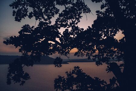 Majestic sunset in the mountains landscape over a calm lakeの写真素材