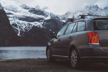 Travel concept. Car on the background of snow-capped mountains and lakes. Shoot from the back. Can use as bannerの写真素材
