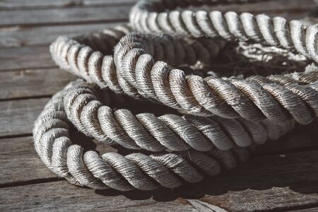 Close up of worn out thick mooring rope on wooden pier.の写真素材