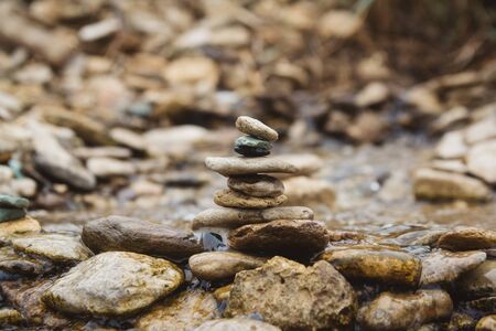 Stones pyramid on pebble beach symbolizing stability, zen, harmony, balance. Shallow depth of fieldの写真素材