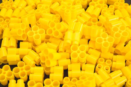 Plastic bricks of yellow color and details of the toy. Yellow backgroundの写真素材