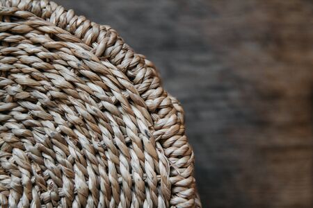 Element of a round wicker basket on a wooden background. Pattern of round texture. Top view. Copy, empty space for textの写真素材