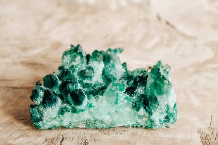 Raw emerald and gemstone rough rock crystal on a wooden table. Copy, empty space for text.の写真素材