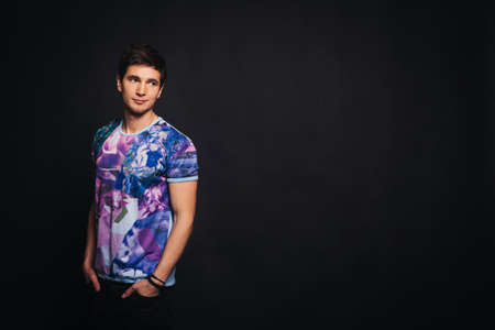 Young man sports appearance dressed in a color polo shirt on a black background. Place for text and logoの写真素材