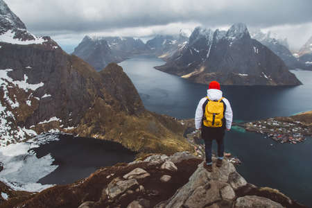 Man traveler hiking on Reinebringen mountain ridge in Norway lifestyle adventure travelingの写真素材