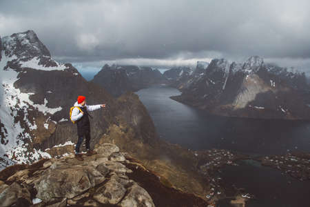 Man traveler hiking on Reinebringen mountain ridge in Norway lifestyle adventure travelingの写真素材