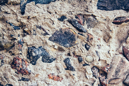 Structure of concrete surface with admixtures of stones as background image. Rough building material of gray colorの写真素材